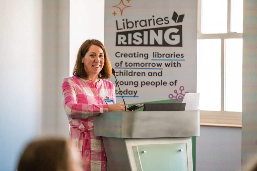 woman smiling presenting at lectern