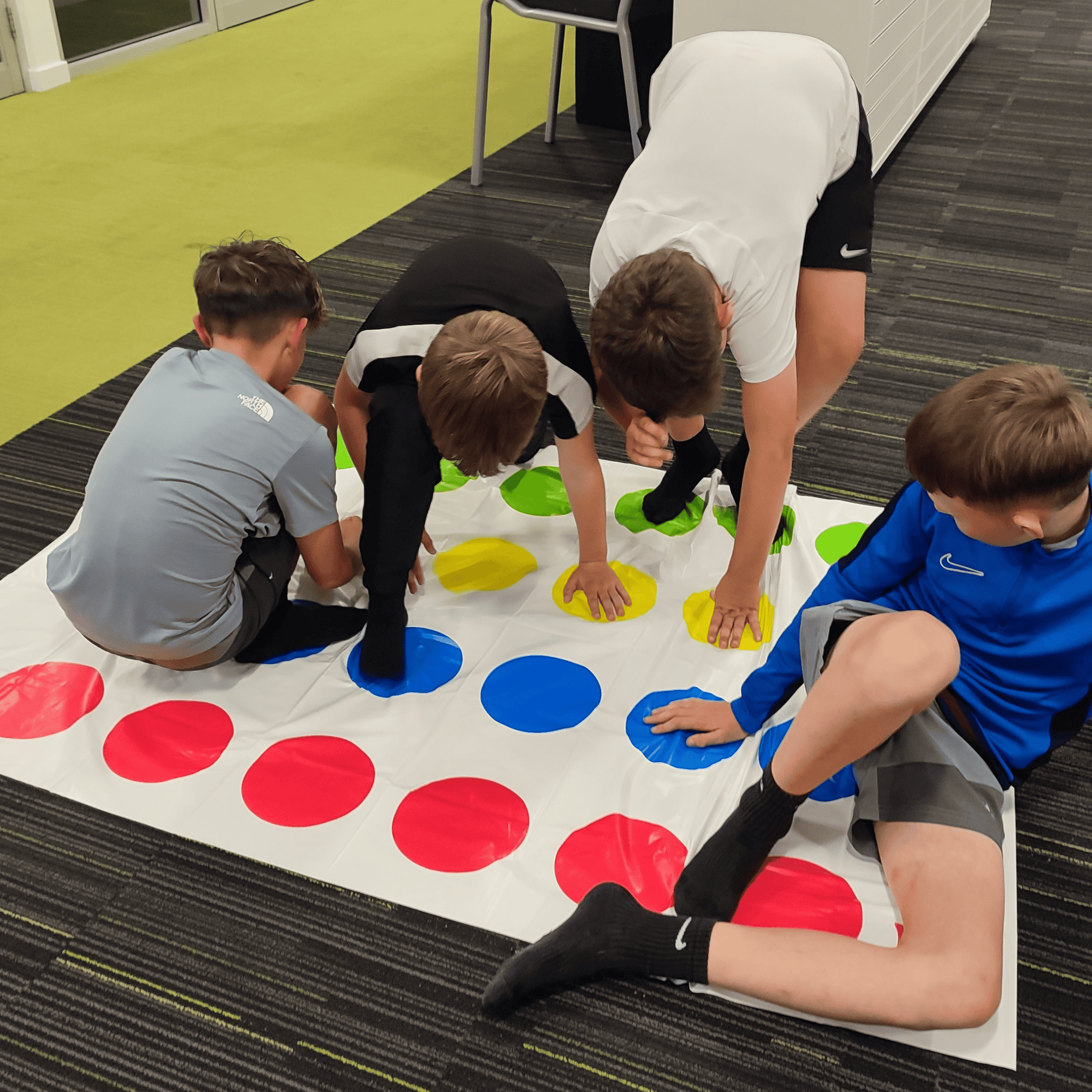 4 boys playing twister